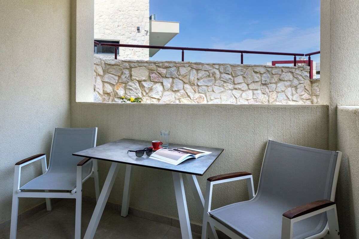 Un balcón con dos sillas, una mesa y una revista.
