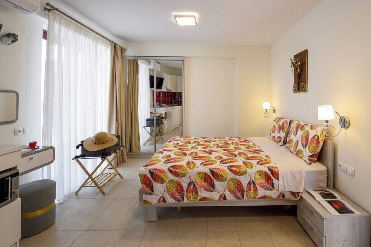 Ein Schlafzimmer mit Bett, Nachttischen, Schreibtisch, Stuhl, Spiegel und Kleiderschrank.