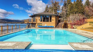 A pool area with a wooden building, a view of the lake, and a clear sky. - Million Dollar Views of Lake Tahoe - #13 (Kings Beach)