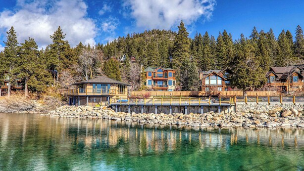 A lakeside property with multiple cabins, a dock, and a forested backdrop. - Million Dollar Views of Lake Tahoe - #13 (Kings Beach)