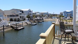 A marina with boats docked, a wooden deck, and a chair.
