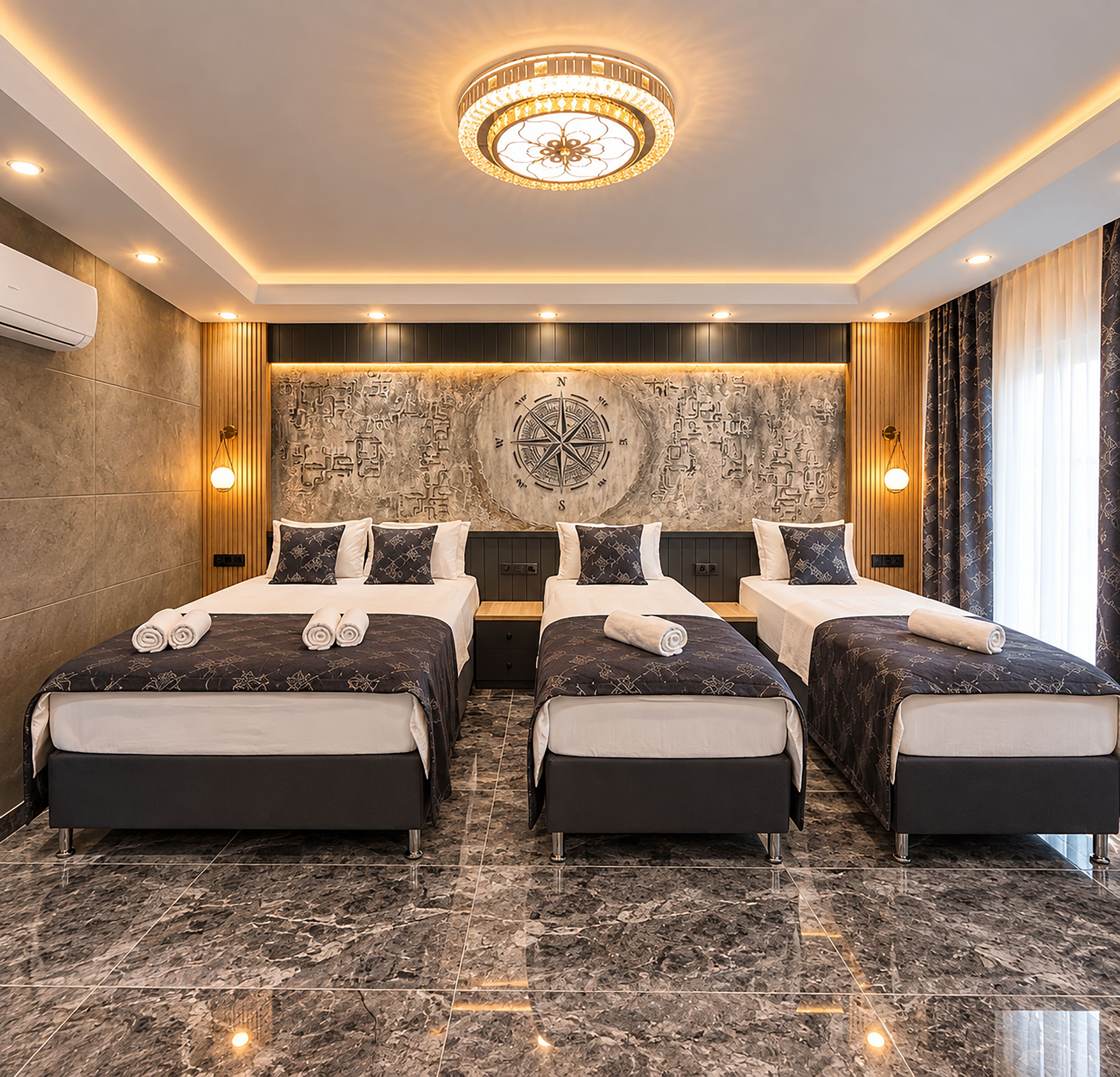Habitación de hotel con dos camas, un mural grande en la pared y una lámpara de araña moderna.