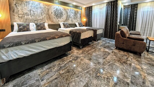 A hotel room with two beds, a sofa, and a large wall mural. - Tikir House (Denizli)