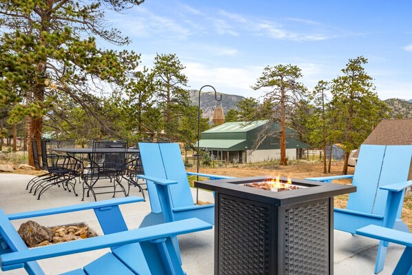 An outdoor seating area with blue chairs and a black fire pit.