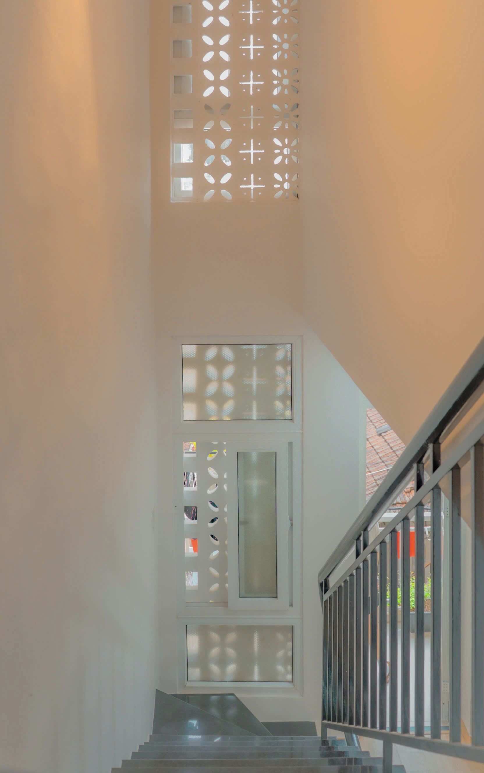 Un escalier avec une porte en verre et un panneau décoratif au-dessus.