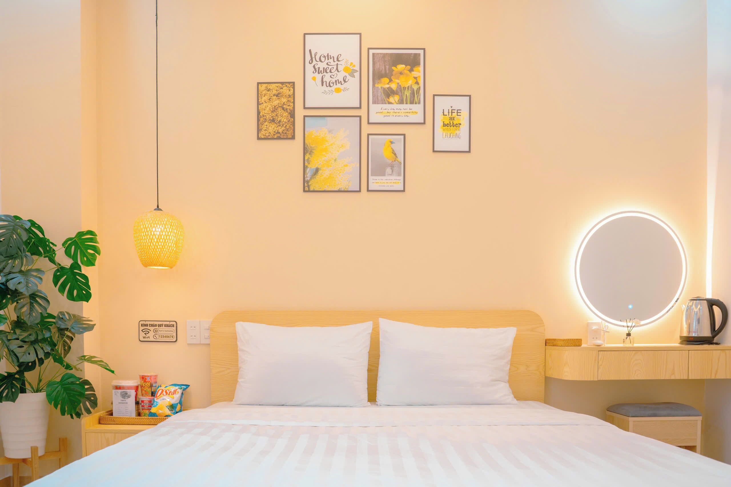 Una camera d'albergo con un letto, un comodino, una lampada e opere d'arte alle pareti.