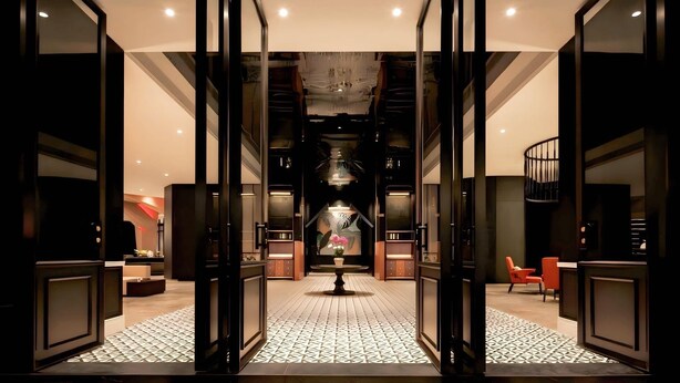 A modern hotel lobby with a central chandelier, a staircase, and a seating area. - BONINGHOTEL (Meishan)