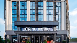 A modern hotel building with a prominent entrance and signage. - BONINGHOTEL (Meishan)