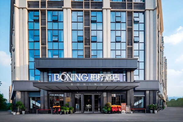 Un moderno edificio de hotel con una entrada destacada y señalización.