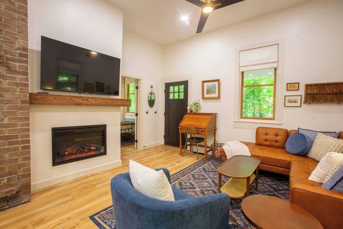 Una sala de estar con chimenea, televisor, piano y sofá.