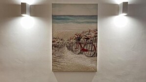 Un tableau représentant un vélo sur une plage, avec une clôture en arrière-plan.