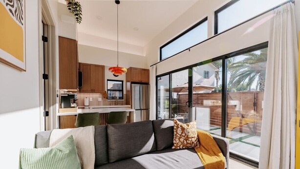 A modern living room with a sofa, a dining area, and a kitchen. - 25% off, Chic Casita • Hot tub • BBQ • 4 min to SDSU (La Mesa)