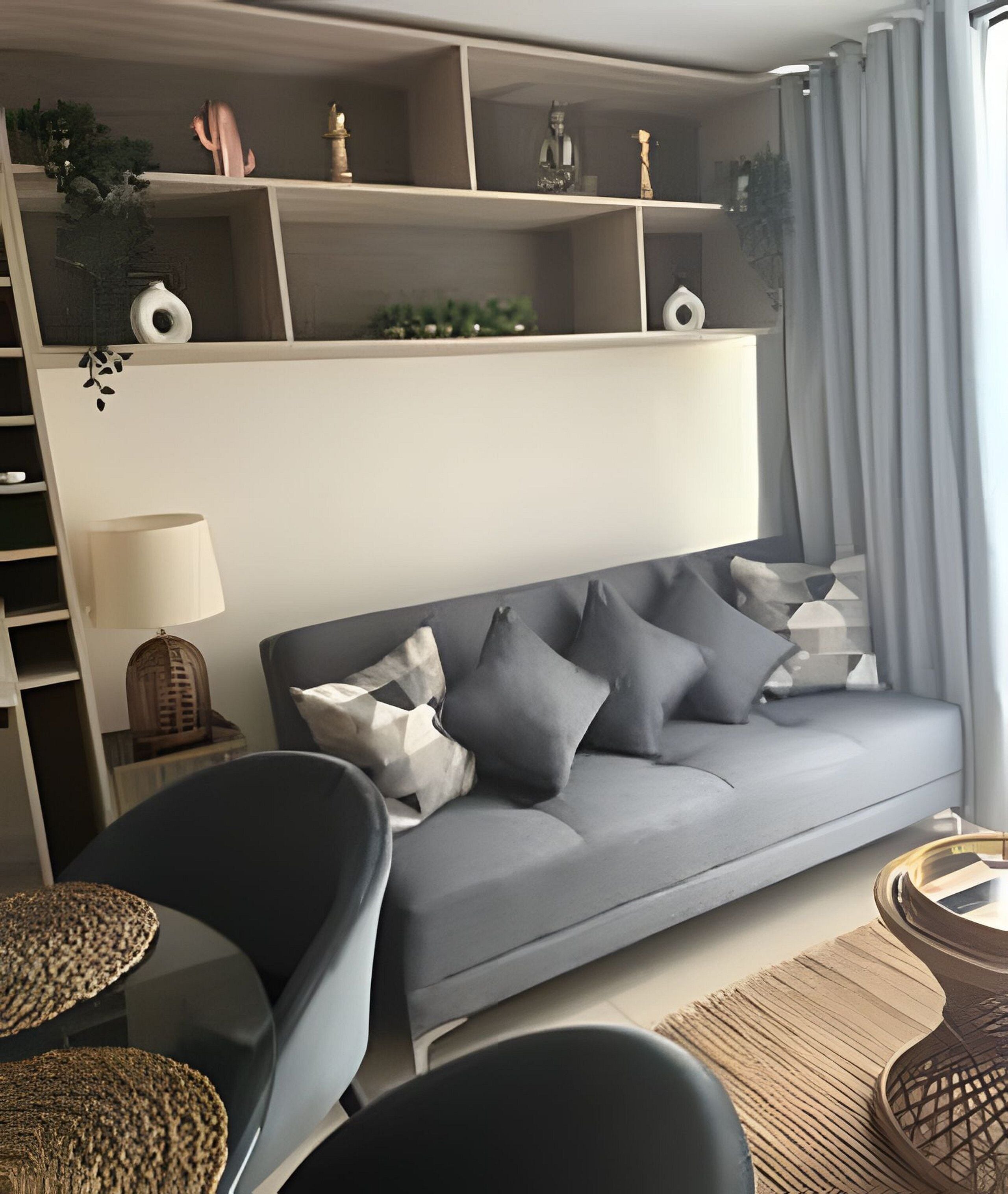 A modern living room with a grey sofa, a side table, a lamp, and decorative items on shelves.