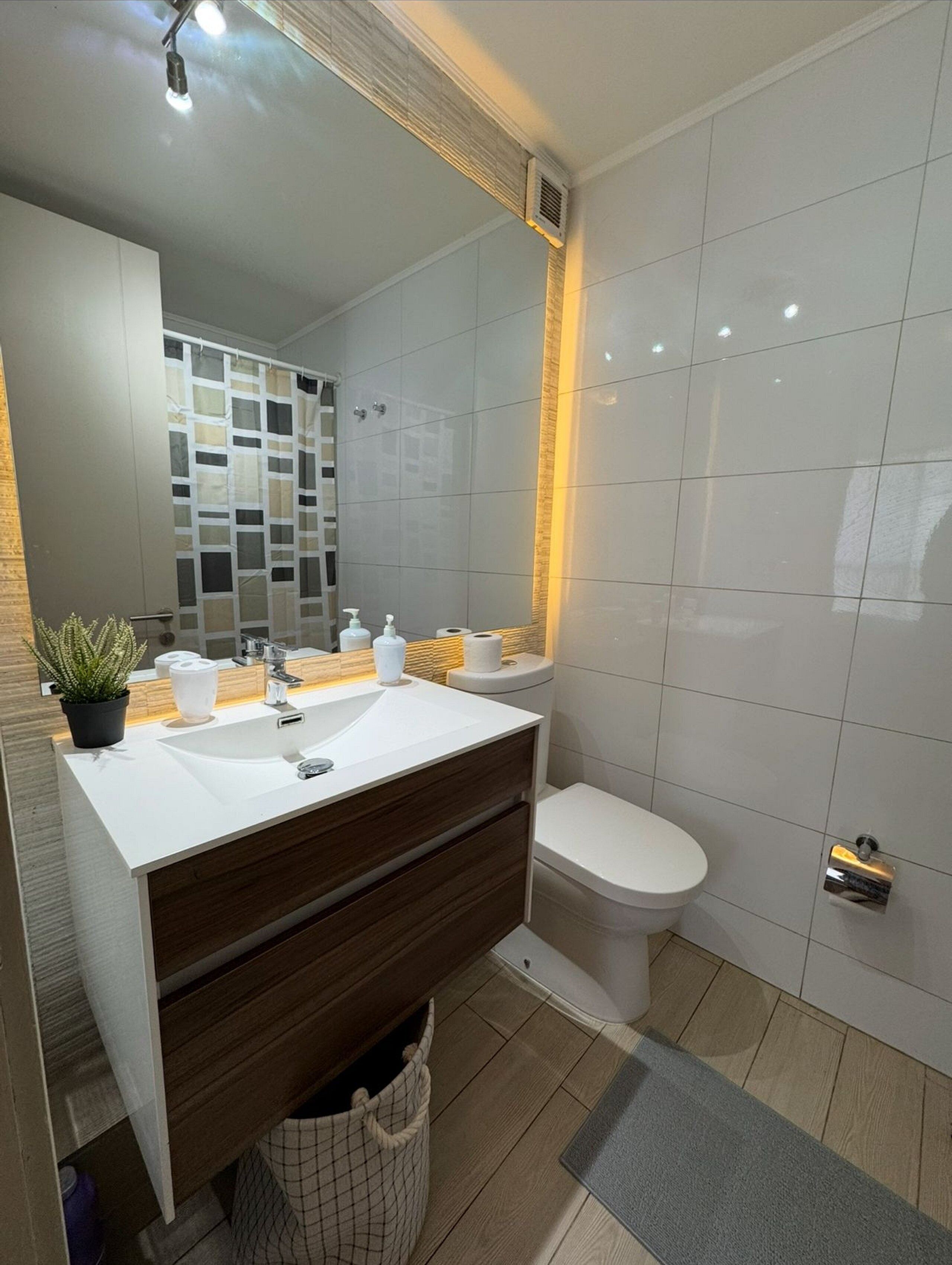 Ein modernes Badezimmer mit Waschbecken, Holzschrank und Toilette.