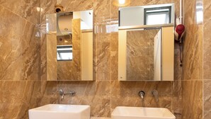 A bathroom with two sinks, marble walls, and a mirror. - Hanoi Central Pod (Hanoi)