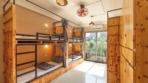 A room with bunk beds, a fan, and a view of the outdoors. - Hanoi Central Pod (Hanoi)