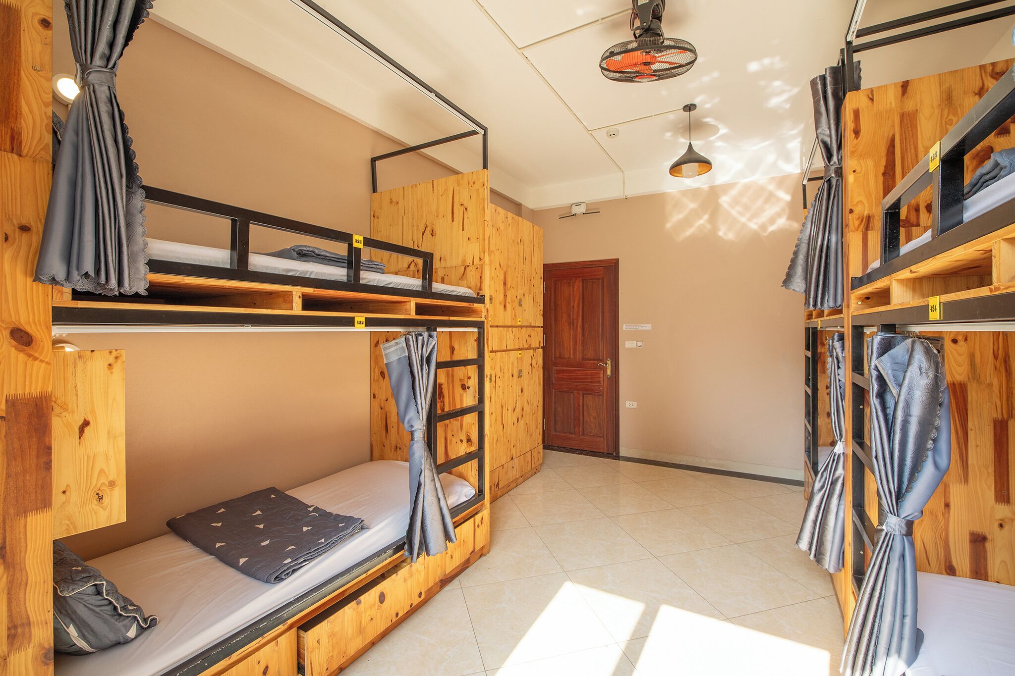 A bunk bed room with wooden walls and a ceiling fan.