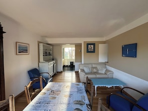 Un salon comprenant une table à manger, des chaises, un canapé et un téléviseur.