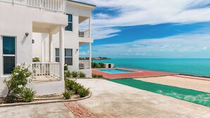 Un bâtiment blanc avec une piscine et une vue sur la plage.