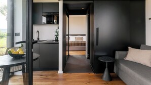 A modern interior with a kitchen, dining area, and a sofa. - Scorzamara Exclusive Country Lodges - Private Pool or Jacuzzi (Melilli)