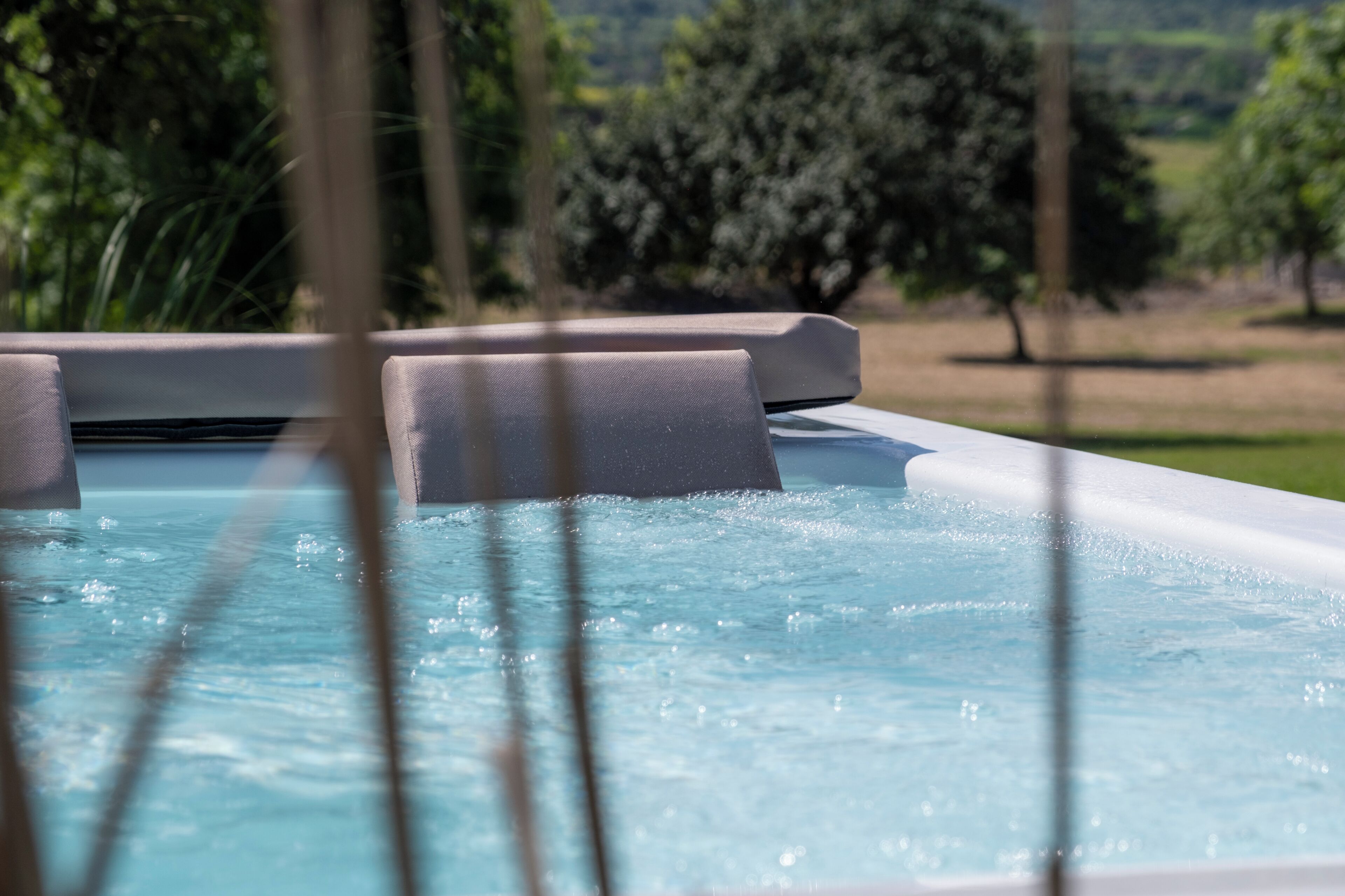 A hot tub with a view of a green landscape.