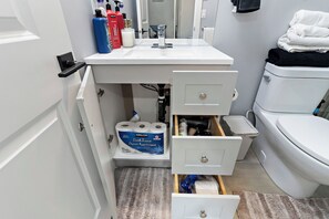 Ein Badezimmer mit Waschbecken, Toilette und Stauraumschränken.