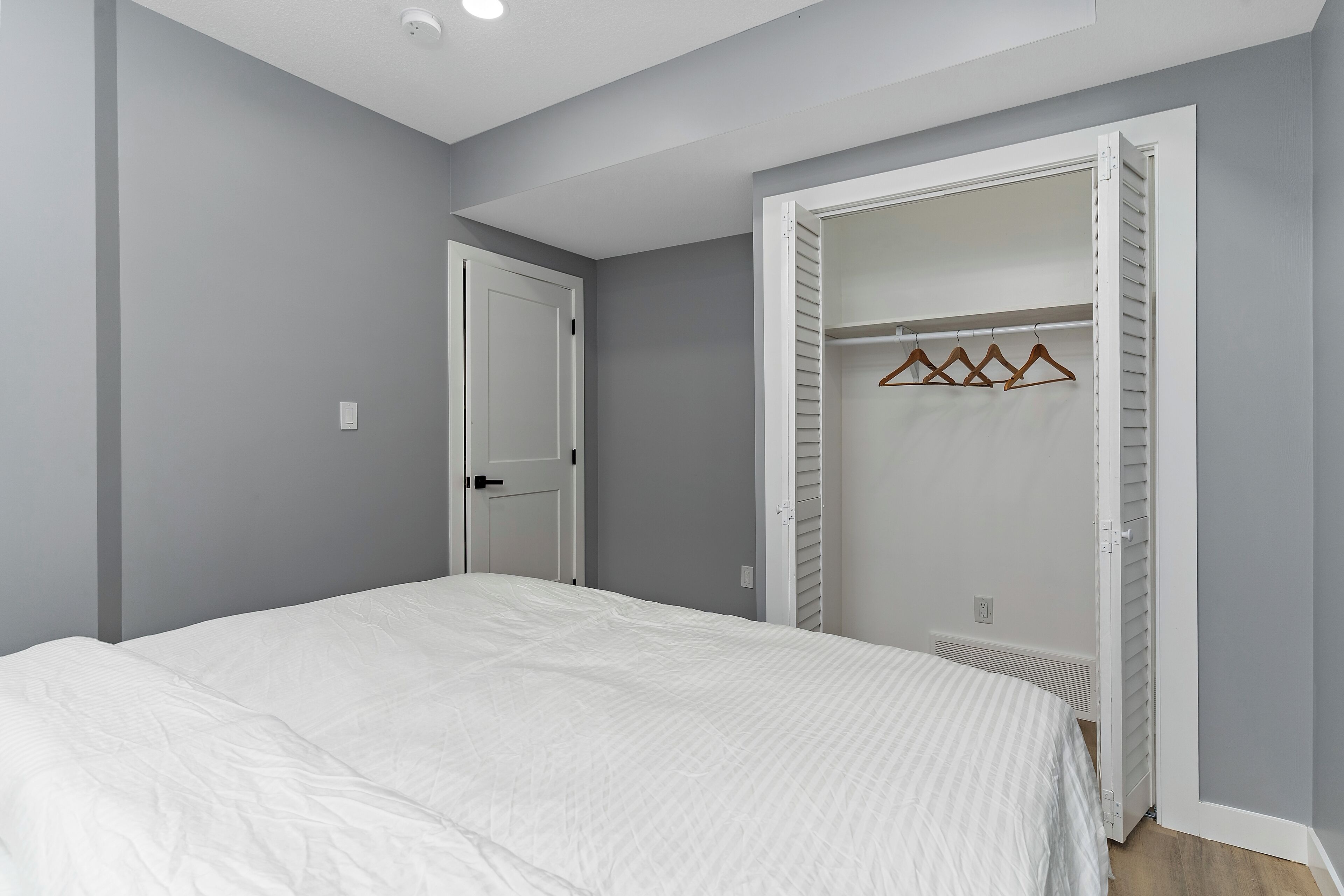 Une chambre à coucher avec un lit, une armoire et une porte.