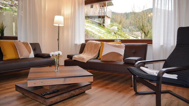 Una sala de estar moderna con un sofá, un sillón y una mesa de centro.