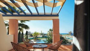 A covered outdoor area with a pool, two wicker chairs, and a view of the sea. - Harmony of Sea View & Nature,1BR (Polis Chrysochous)