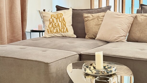 A modern living room with a sofa, a glass coffee table, and decorative pillows. - P071 – Porto Recanati, Three-Room Apartment with Garden and Wi-Fi (Porto Recanati)