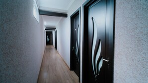 A narrow hallway with wooden flooring and textured walls. - Villa Ikalto (Telavi)