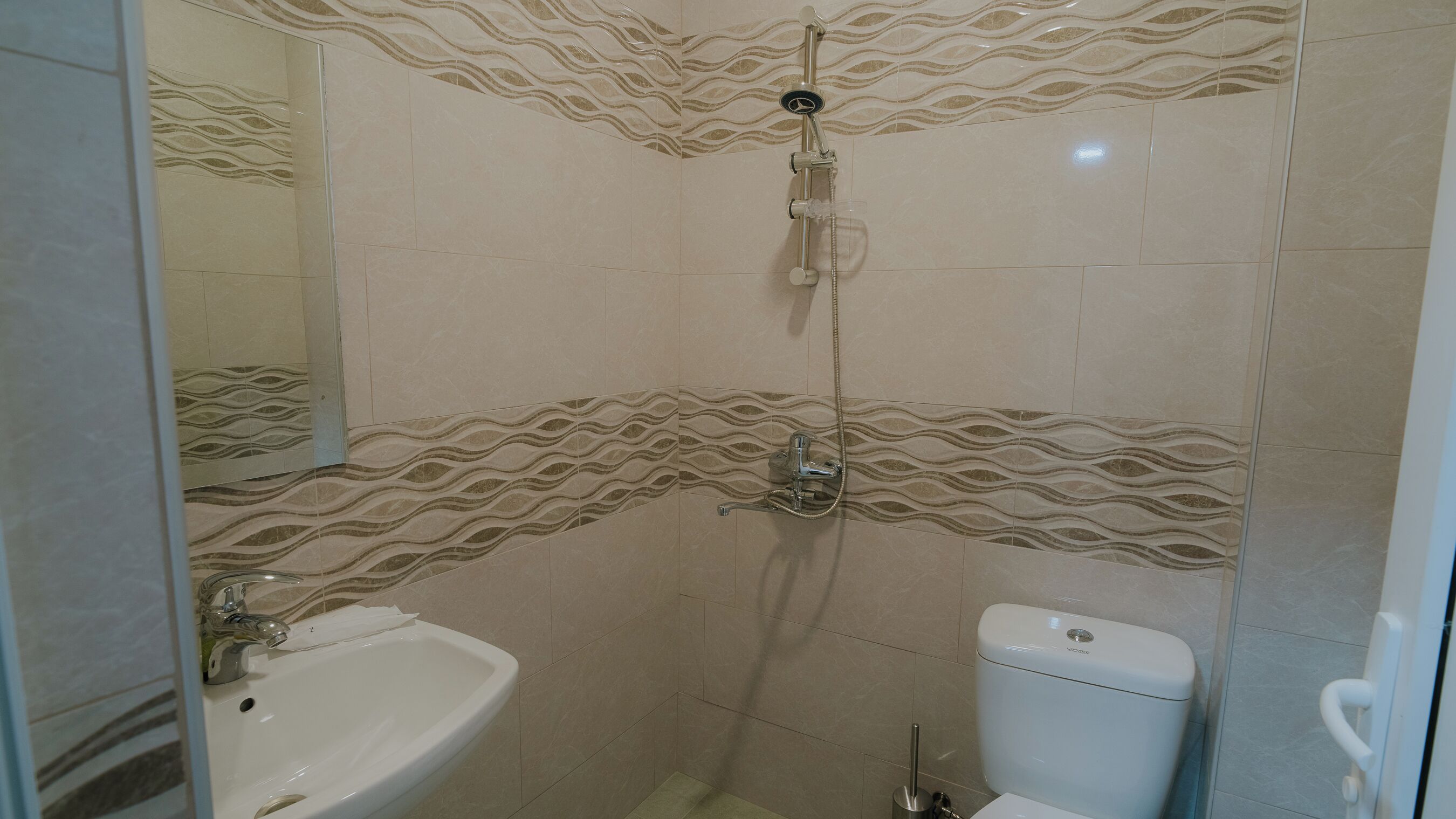 A bathroom with a shower, toilet, and sink.