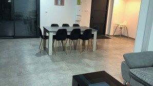 A modern living room with a dining area, a sofa, a coffee table, and a sliding glass door. - Spacious new house with 4 bedrooms - Close to the Loire castles (Joué-lès-Tours)