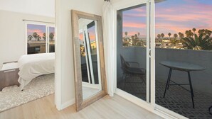 Une chambre d’hôtel avec un balcon, un lit, une chaise et une table.