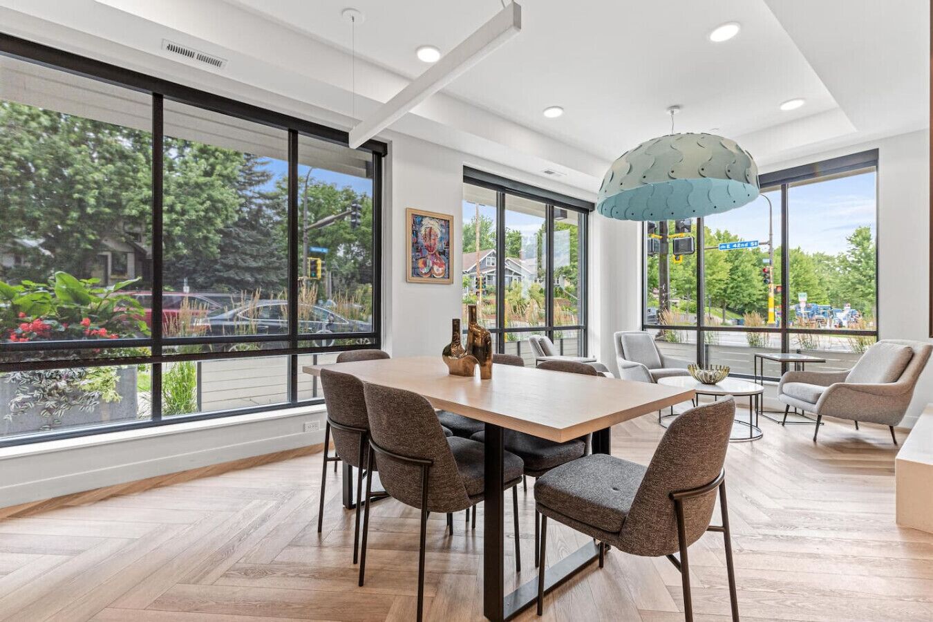 A spacious dining area with a large table, multiple chairs, and a modern pendant light.