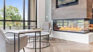 Un salon moderne doté d’une grande cheminée, d’une table à manger et de sièges confortables.