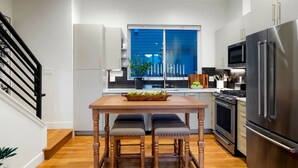 A modern kitchen with a wooden table, two chairs, a refrigerator, and a stove. - Million $ Rooftop MTN Views -2 King Beds-DT Golden (Golden)
