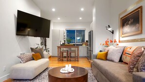 A modern living room with a sofa, a coffee table, and a TV mounted on the wall. - Million $ Rooftop MTN Views -2 King Beds-DT Golden (Golden)
