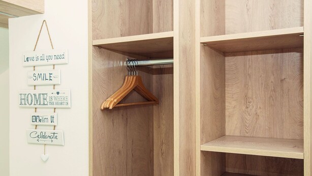 A wooden wardrobe with hanging space and motivational wall decorations. - Old Town Rooms Piran (Piran)