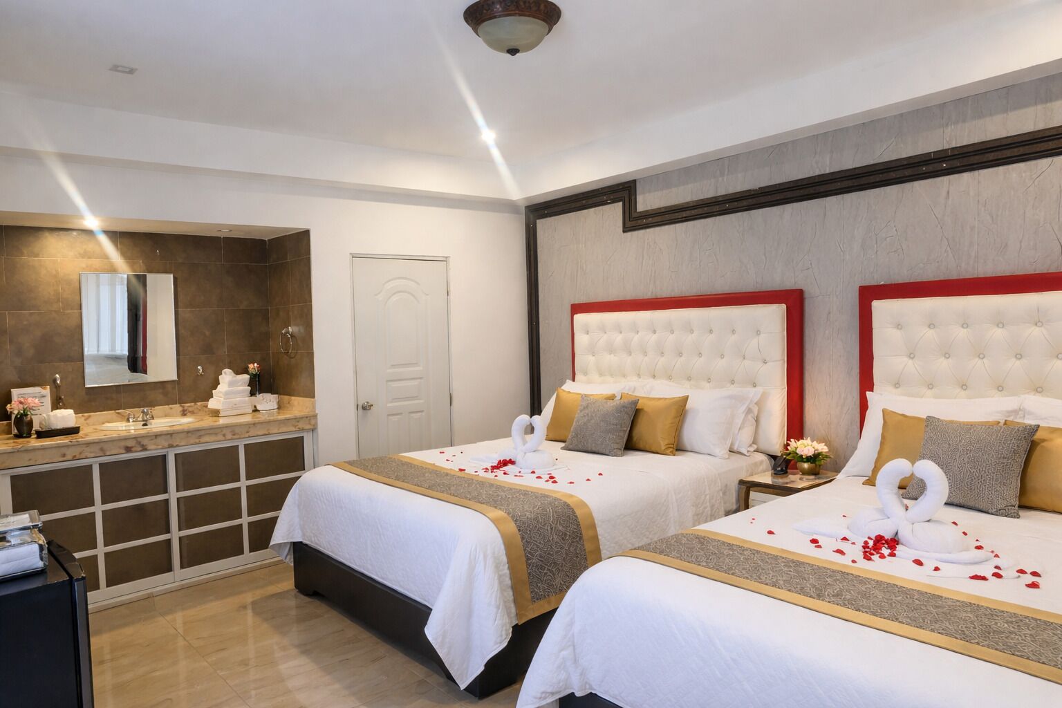 Une chambre d’hôtel avec deux lits, une salle de bain et un mini-bar.