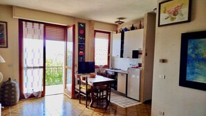 Una cocina compacta con comedor, un refrigerador y una pequeña mesa con una silla.