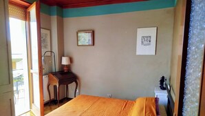 Una habitación con cama, escritorio, silla y lámpara.