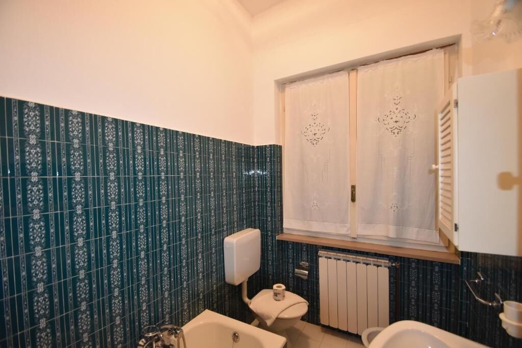 A bathroom with a toilet, bidet, and bathtub.