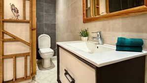 Un baño moderno con un lavabo blanco, un espejo y un inodoro.