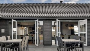 A modern building with a tiled roof and open patio area. - 5 Star Holiday Home in Norre Nebel (Norre Nebel)