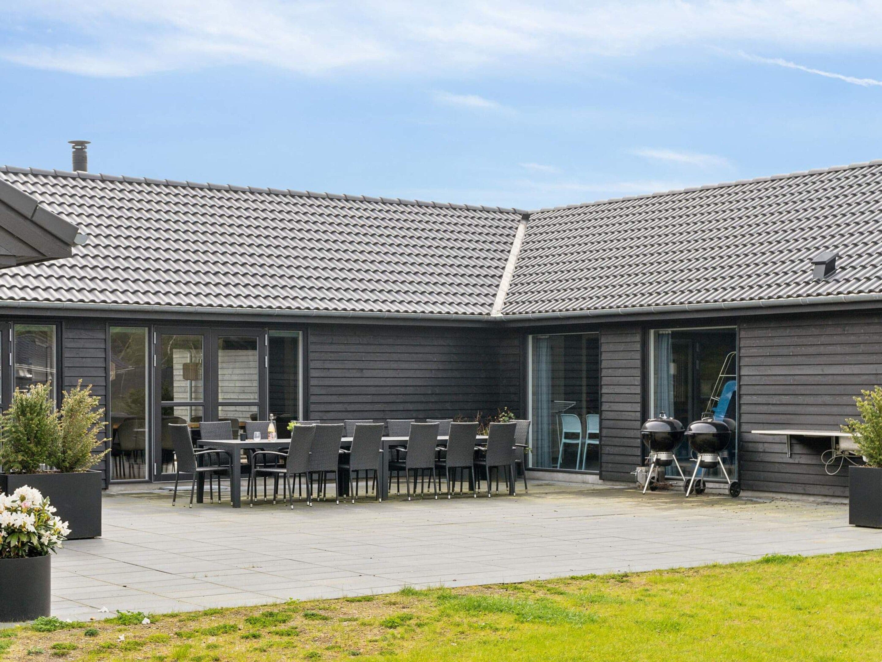 Ein moderner Außenbereich mit Terrassengarnitur und zwei Grillstationen.