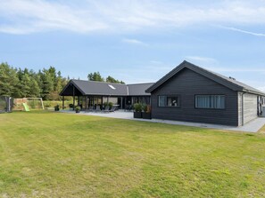 A modern two-story house with a covered patio and a grassy yard. - 5 Star Holiday Home in Norre Nebel (Norre Nebel)