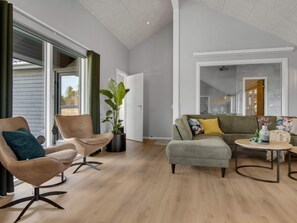 A modern living room with a sofa, armchair, and coffee table. - 5 Star Holiday Home in Norre Nebel (Norre Nebel)