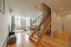 A spacious living area with a wooden staircase, a sofa, and a coffee table. - Heart OF Porto Apartment E Duplex by Vacationy (Porto)