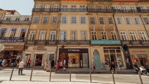 A multi-story building with various storefronts, including a visible pharmacy and a clothing store.